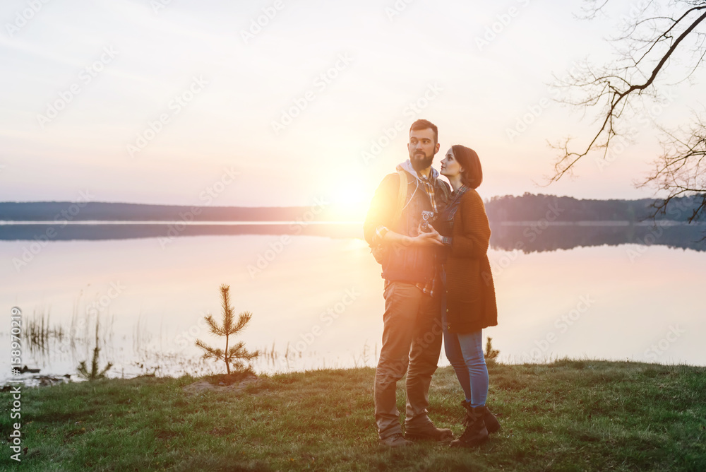 Fototapeta premium Young tourist couple at sunset sun