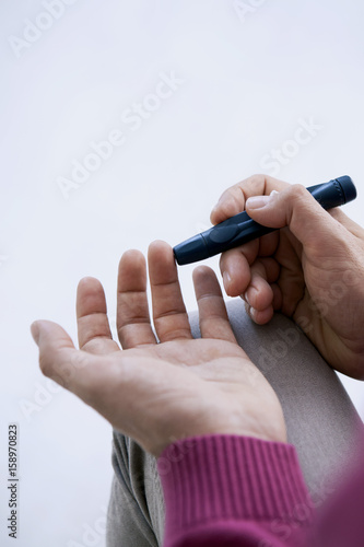 Man checking his blood glucose level © RFBSIP