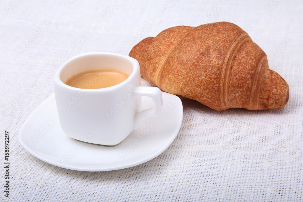 Crispy homemade fresh croissants and cup of coffee espresso on a white background, morning breakfast, selective focus Crispy homemade fresh croissants and cup of coffee espresso on a white background, morning breakfast, selective focus