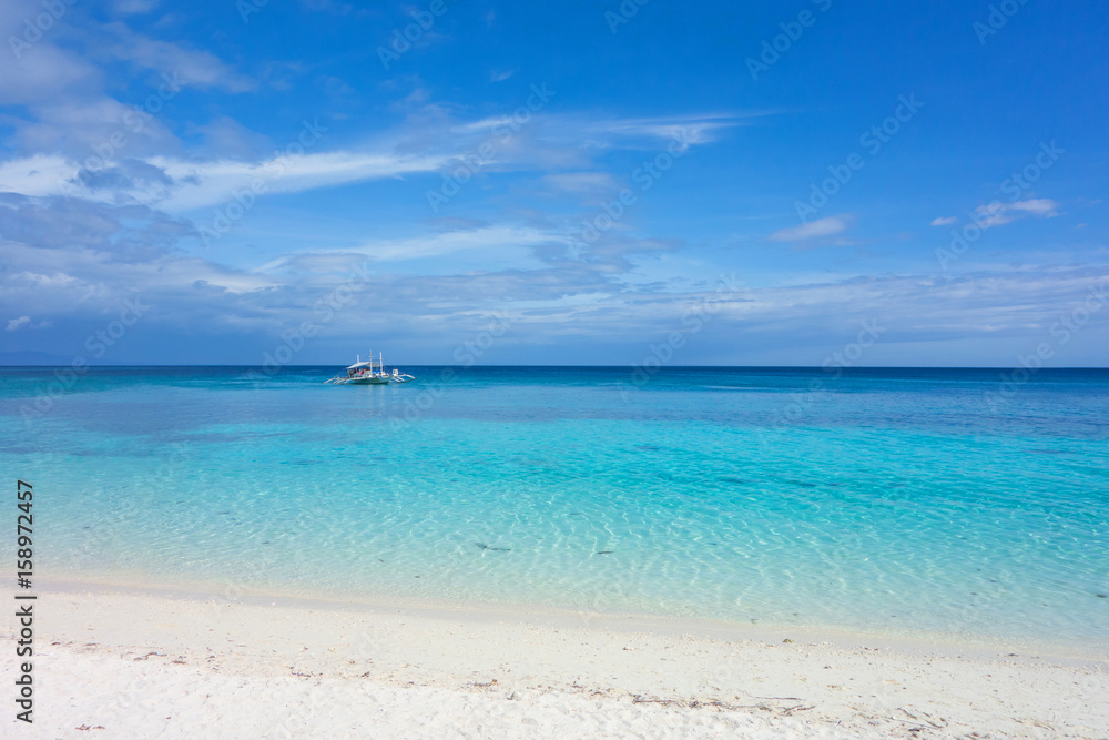 White clouds and Banca boat on blue sky over calm sea. Clear blue water with fantastic white sand beach. Summer outdoor nature holiday serenity. Kalanggaman Island, Philippines. Background,