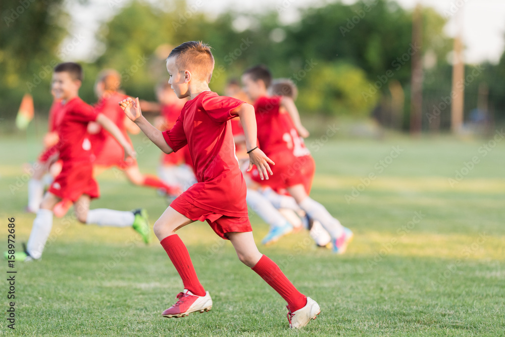 Obraz premium Kids soccer football - children players exercising before match on soccer field