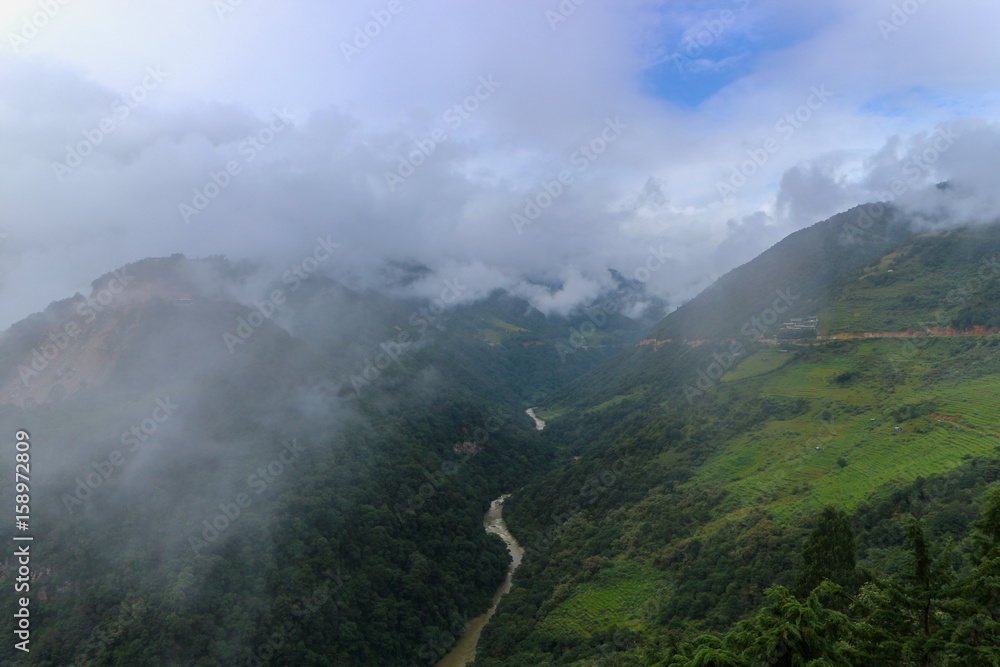 Scenery of foggy hills and Mangde River in Bumthang, Bhutan