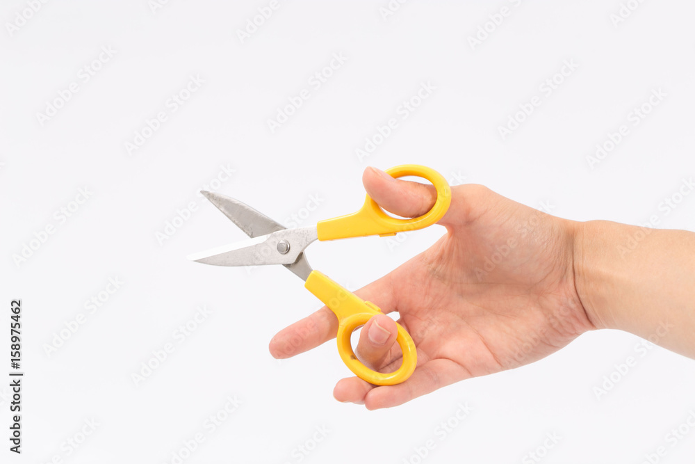 Female hands on a white background with scissors Female hands on a white background with scissors