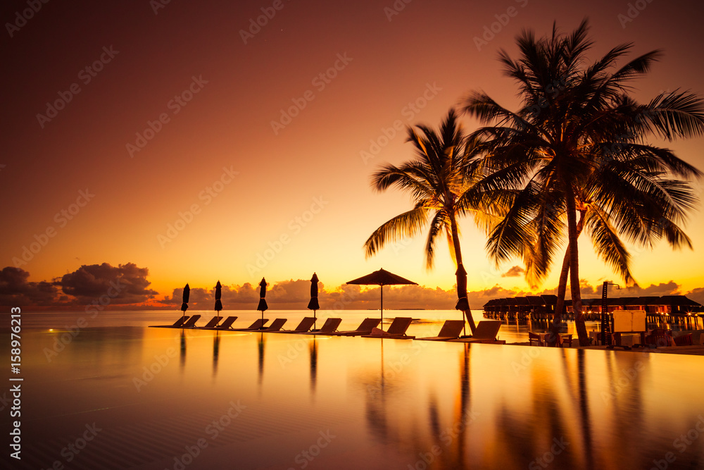 Luxury poolside on the beach with sunset colors. Amazing luxury summer background