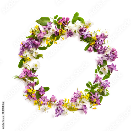 Frame from a variety of wild flowers in the shape of a circle on a white background..