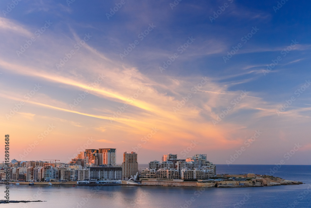 Sliema, major residential and commercial area and a centre for shopping, dining, and cafe life in Malta. Skyline in the Strand and Tigne Point at sunset as seen from Valletta