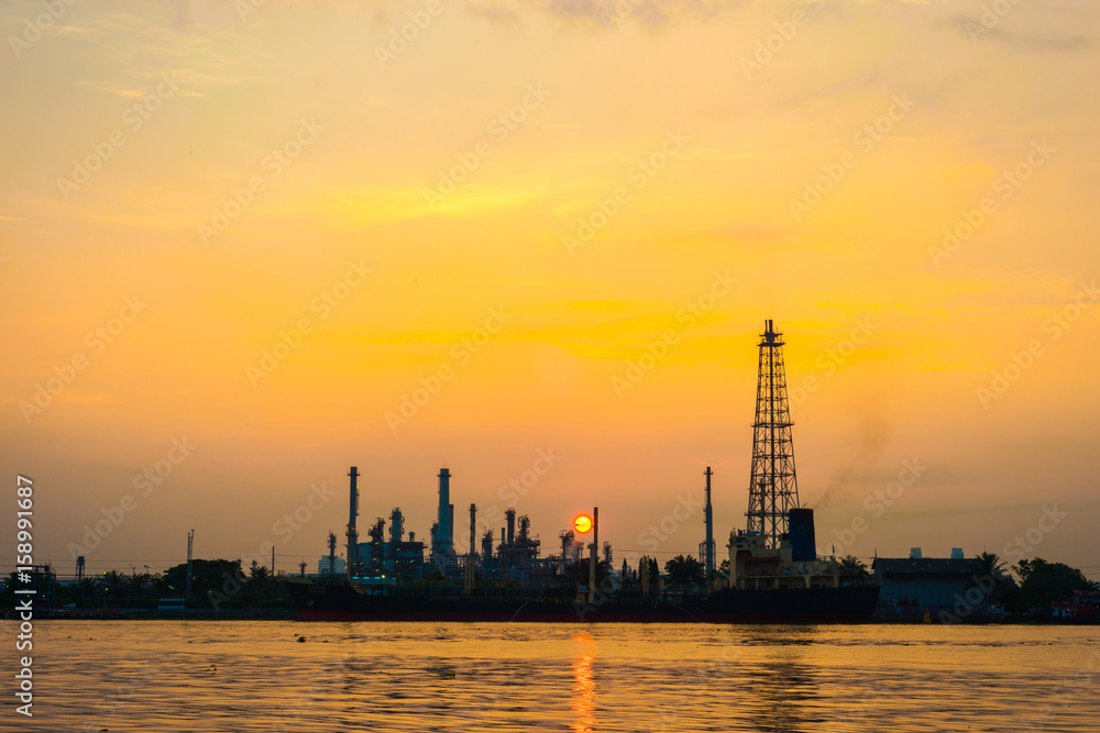 Oil refinery petrochemical industry with river sunrise