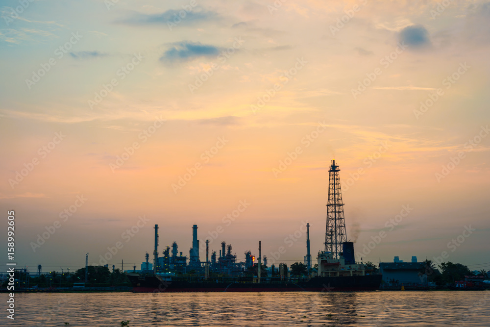 Oil refinery petrochemical industry with river sunrise