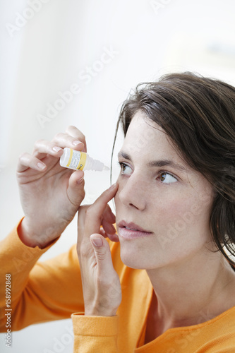 Woman using eye lotion