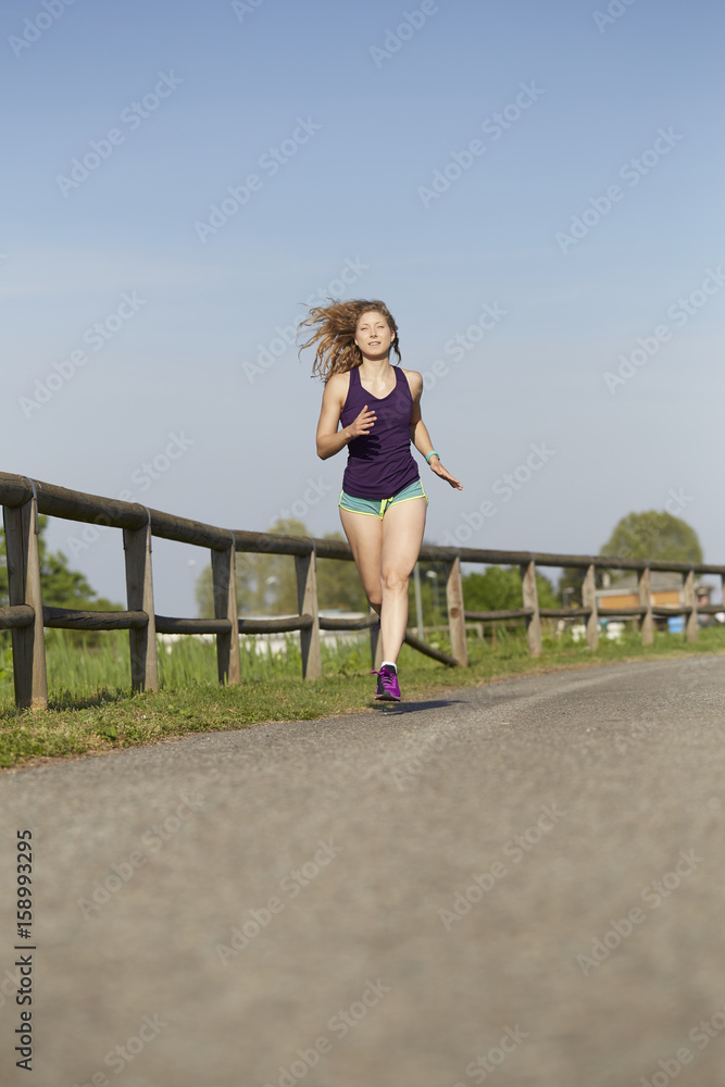 Running woman in park in summer training