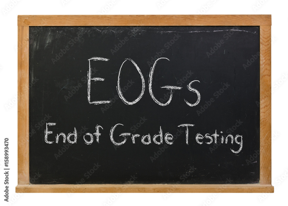 Fototapeta premium EOGs End of Grade Testing written in white chalk on a black chalkboard isolated on white