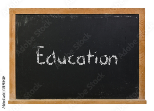 Education written in white chalk on a black chalkboard isolated on white
