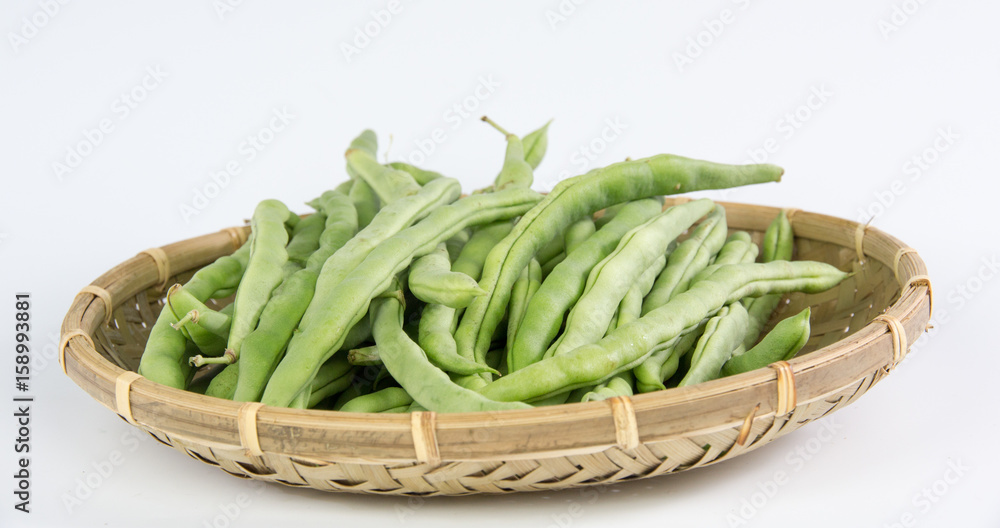 Green bean in a bamboo basket isolated on white background Green bean in a bamboo basket isolated on white background