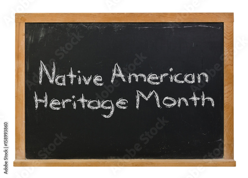 Native American Heritage Month written in white chalk on a black chalkboard isolated on white 