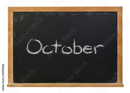 October written in white chalk on a black chalkboard isolated on white
