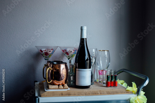 Drinks trolley with wine bottle, glasses and tankards