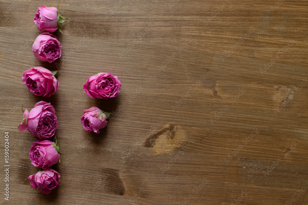 Floral background on wooden table with white and rose roses Floral background on wooden table with white and rose roses