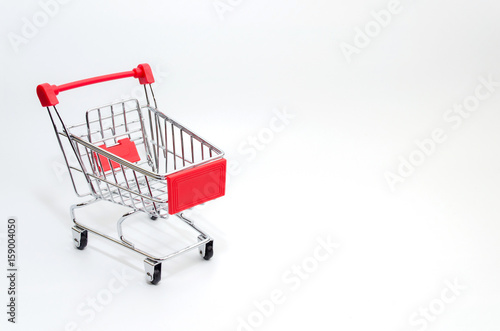 mini supermarket shopping cart on white background, holiday sale and shopping concept, selective focus, copy space © Vittaya_25