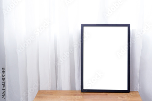 Empty black frame with place for text of on table. Scandinavian hipster style room interior.