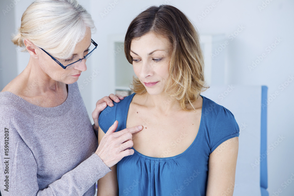Doctor examining the upper chest of a patient Doctor examining the upper chest of a patient