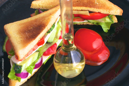 Vegetarian sandwich with tomato on a black plate photo