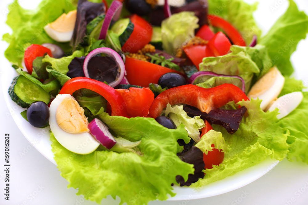 Salad of fresh vegetables and herbs on the table in the plate Salad of fresh vegetables and herbs on the table in the plate