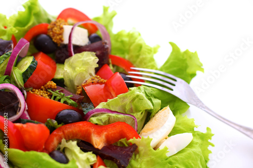 Salad of fresh vegetables and herbs on the table in the plate