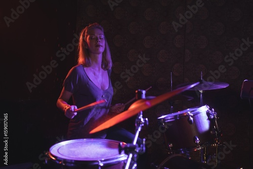 Confident female drummer performing in nightclub