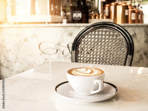 a cup of coffee on white table . Simple breakfast or coffee break in morning/ selective focus.blank seating  indoor in urban cafe. color filter effect photo