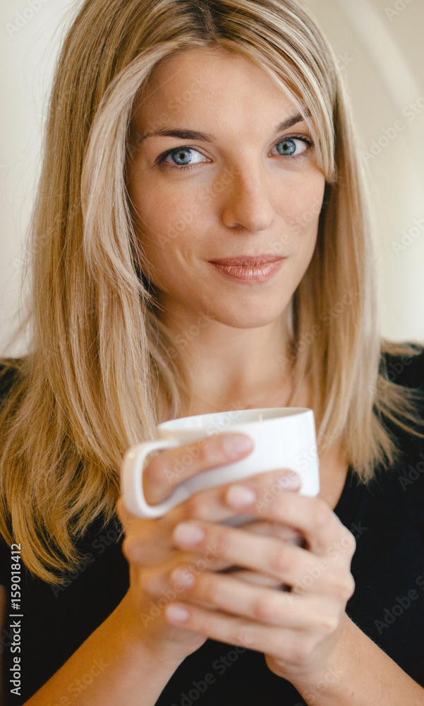 Portrait of beautiful blonde woman drinking coffee at home Portrait of beautiful blonde woman drinking coffee at home