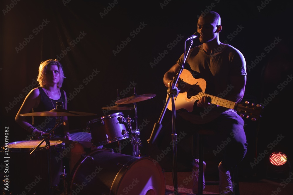 Singer performing with drummer in nightclub