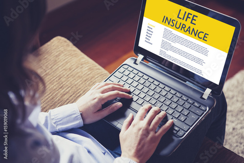 Life Insurance concept: Woman typing in a laptop computer with Life Insurance contract in the screen.