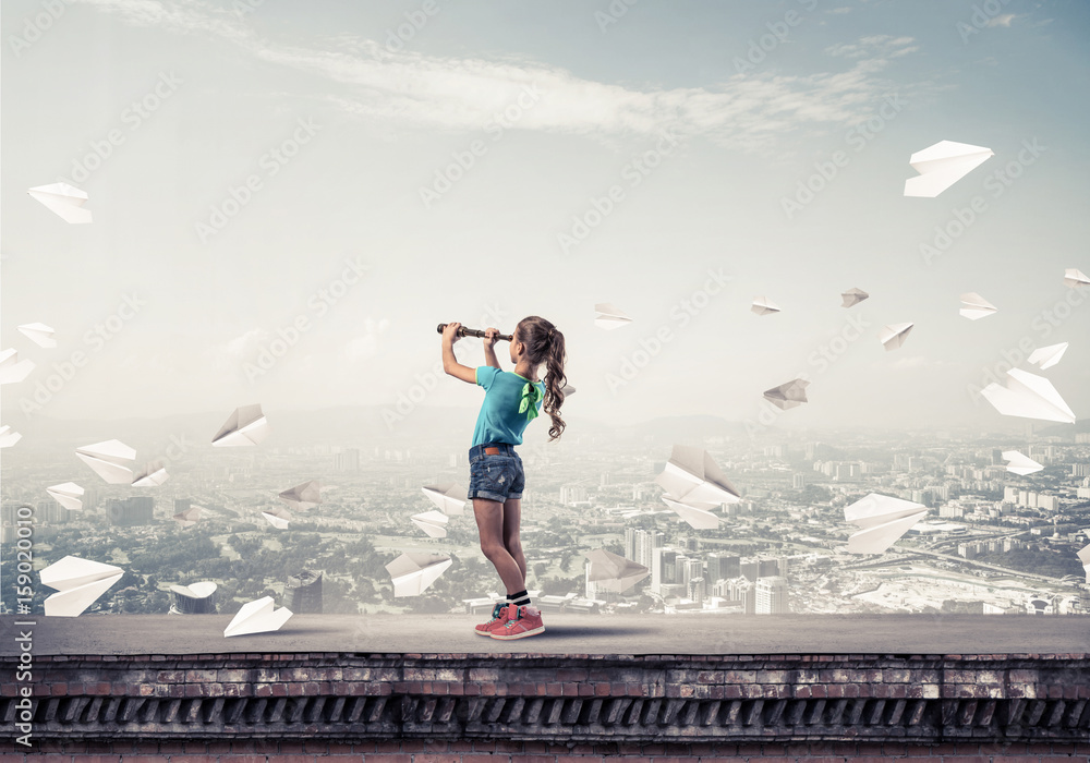 Concept of careless happy childhood with girl exploring this wor Concept of careless happy childhood with girl exploring this wor