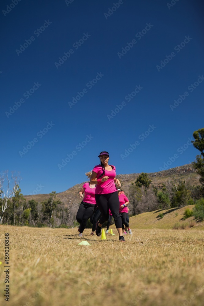 Group of women running through cones in the boot camp Group of women running through cones in the boot camp