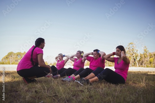 Female trainer instructing women while exercising 