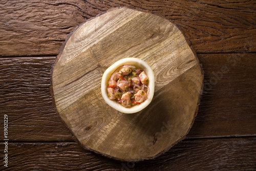 Salmon ceviche with passion fruit sauce on wooden background