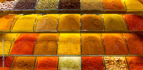 Multicolored spices, teas and nuts on the counter in the market photo