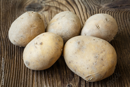 Potatoes on wooden background.