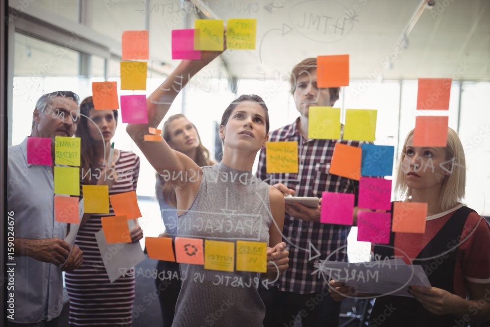 Business people planning with adhesive notes in creative office - obrazy, fototapety, plakaty 