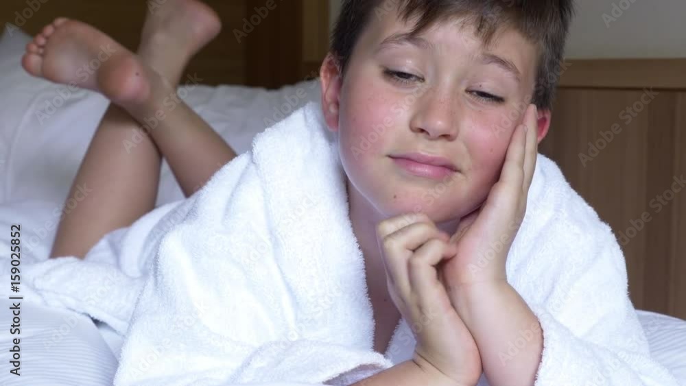 Happy kid relaxing in bed in hotel enjoying view in vacation closeup Happy kid relaxing in bed in hotel enjoying view in vacation closeup
