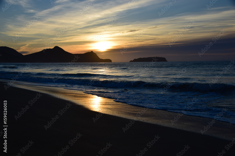 Sunrise over the headland and Atlantic Ocean from the beach at Porto Santo Island, Portugal