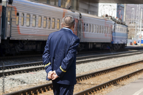 The train conductor awaits his arrival on the platform