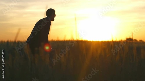 Man in suite and glasses ride his bicycle in field enjoy sunset slow motion  photo