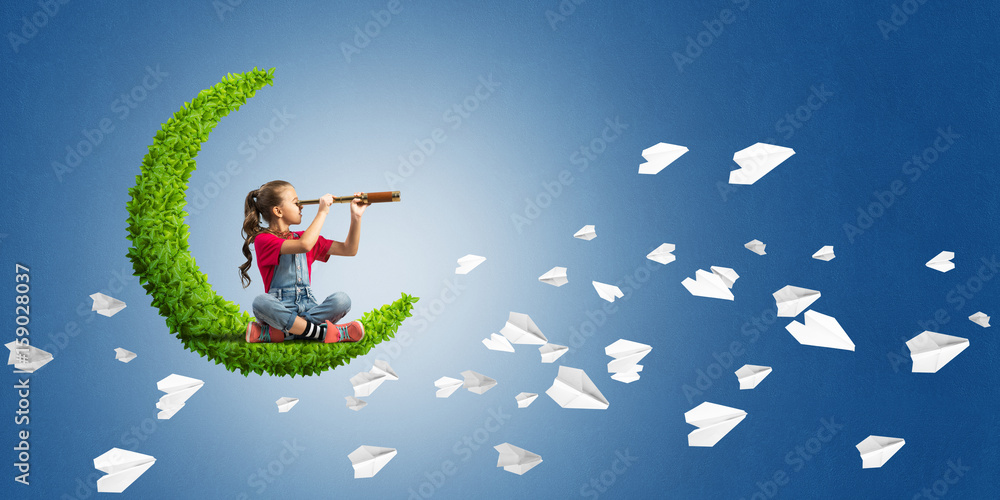 Concept of careless happy childhood with girl on green moon Concept of careless happy childhood with girl on green moon