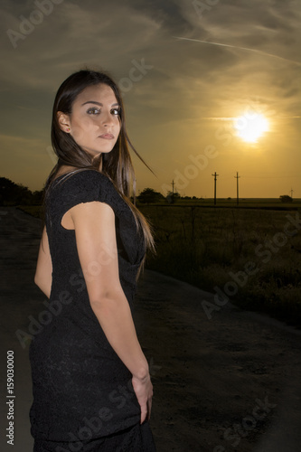 Young girl at sunset wearing a long black dress