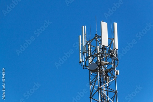 Technology on the top of the telecommunication GSM. Masts for mobile phone signal. Tower with antennas of cellular communication on the background of blue sky.