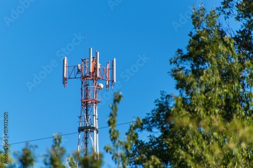 Technology on the top of the telecommunication GSM. Masts for mobile phone signal. Tower with antennas of cellular communication on the background of blue sky.