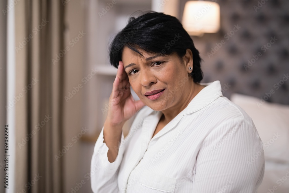 Mature woman suffering with headache at home Mature woman suffering with headache at home