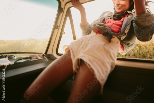 Adventurous young woman hangs outside moving vehicle  photo