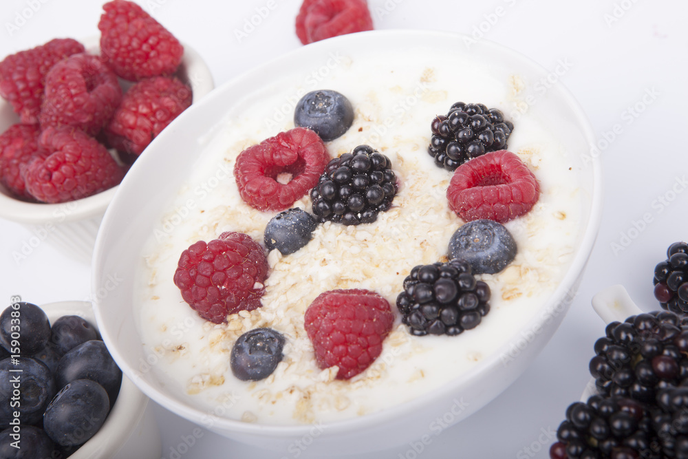 bowl of white yogurt with berries and oat flakes isolated bowl of white yogurt with berries and oat flakes isolated